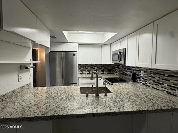 a kitchen with a sink refrigerator and microwave