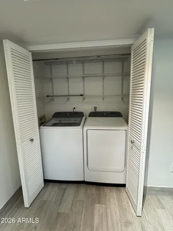 a utility room with wooden floor washer and dryer