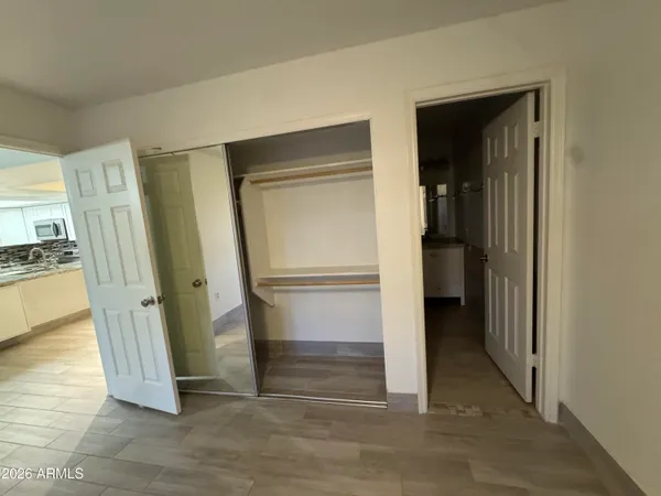 an empty room with wooden floor and closet