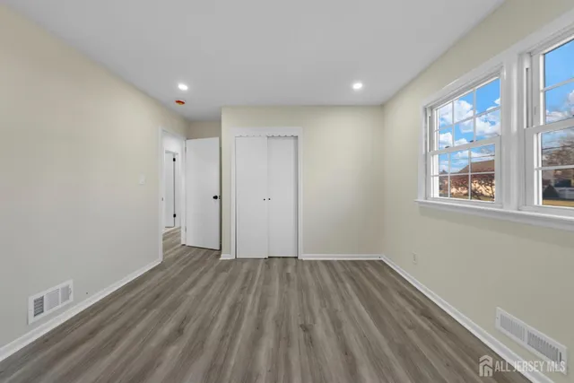 a view of a room with wooden floor and window