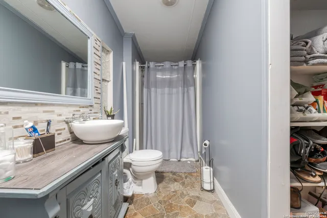 a bathroom with a sink toilet and shower curtain
