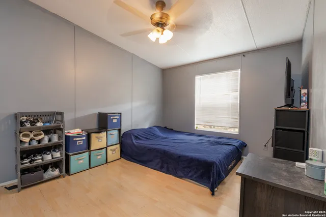 a bedroom with a bed a dresser and a chandelier