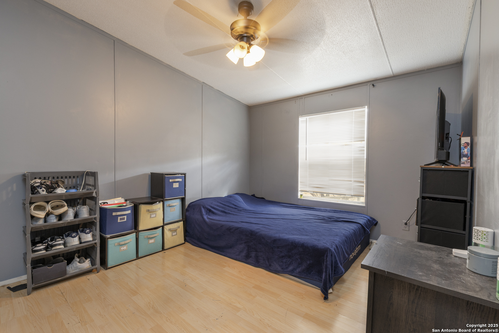 323 County Road 6842 Lytle, TX 78052 - Photo 14 of 25 a bedroom with a bed a dresser and a chandelier