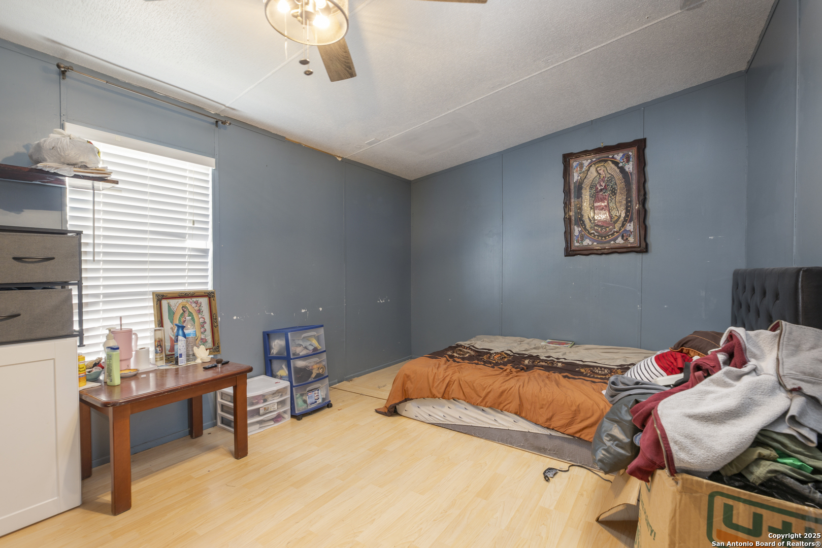 323 County Road 6842 Lytle, TX 78052 - Photo 15 of 25 a bedroom with a bed and a chandelier