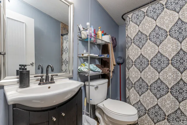a bathroom with a sink toilet and a mirror