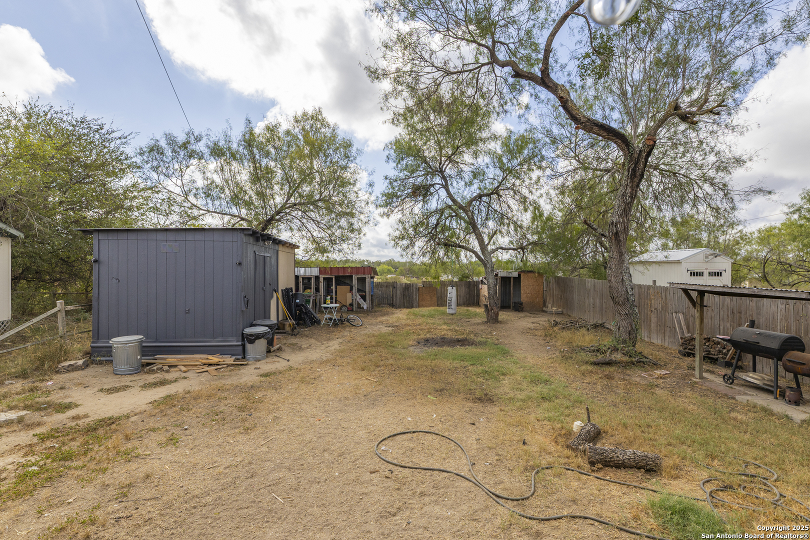 323 County Road 6842 Lytle, TX 78052 - Photo 20 of 25 a backyard of a house with table and chairs