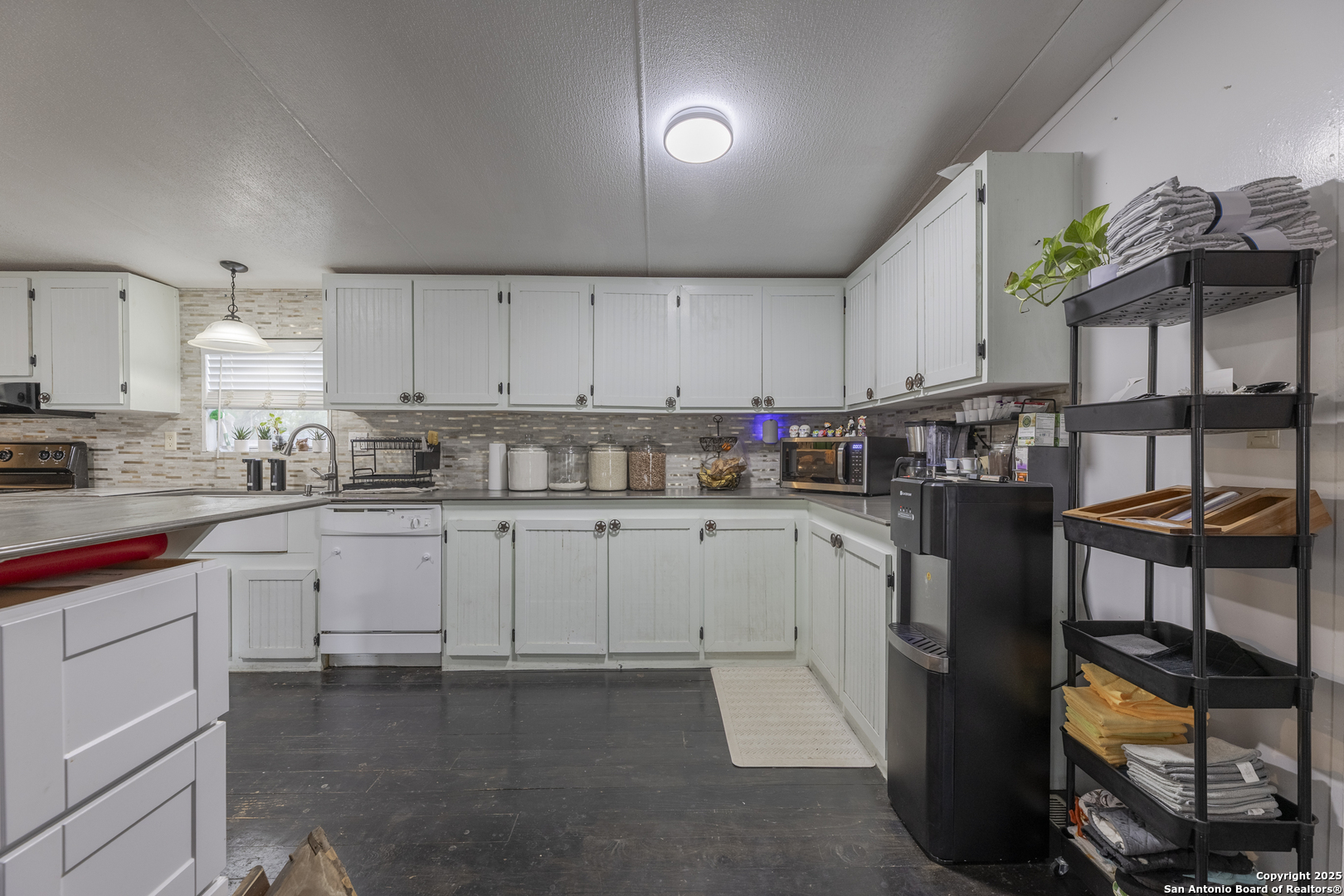323 County Road 6842 Lytle, TX 78052 - Photo 8 of 25 a kitchen with cabinets and window
