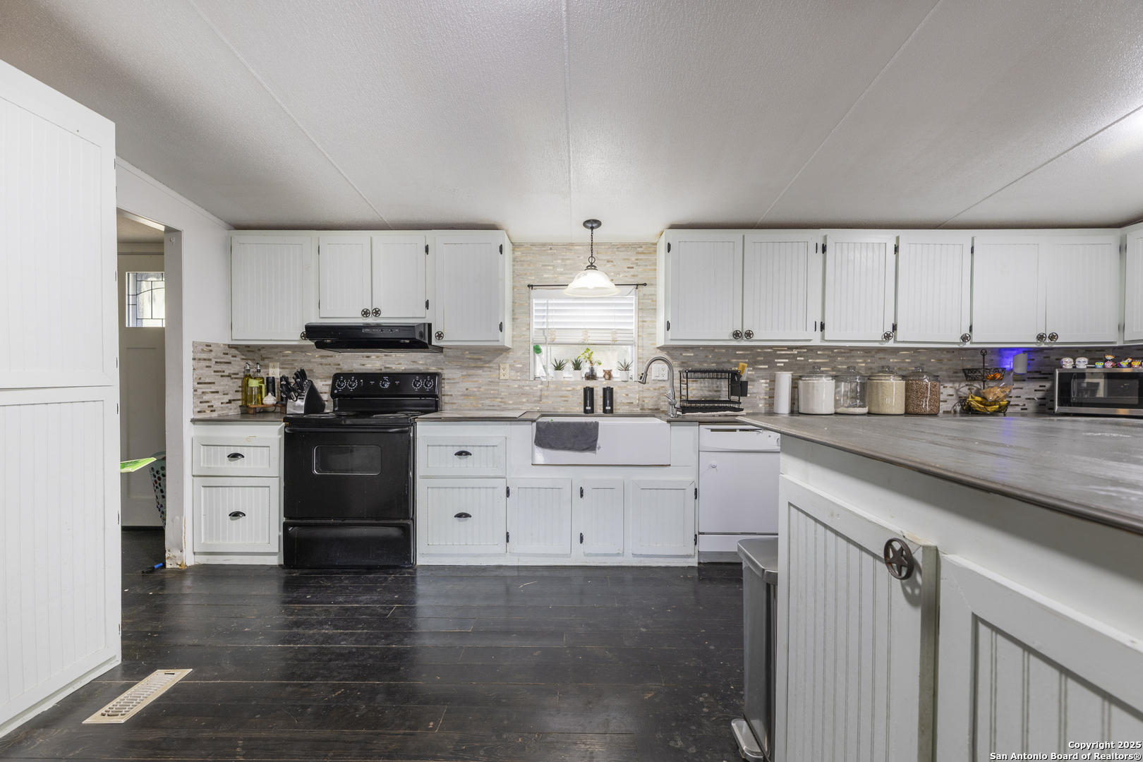 323 County Road 6842 Lytle, TX 78052 - Photo 10 of 25 a kitchen with granite countertop white cabinets and stainless steel appliances