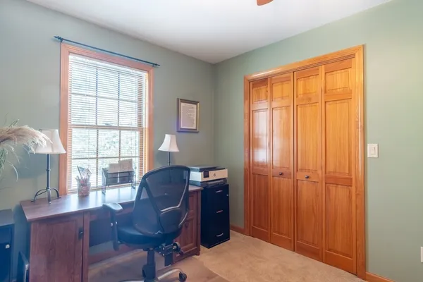 a view of a workspace with furniture and a window