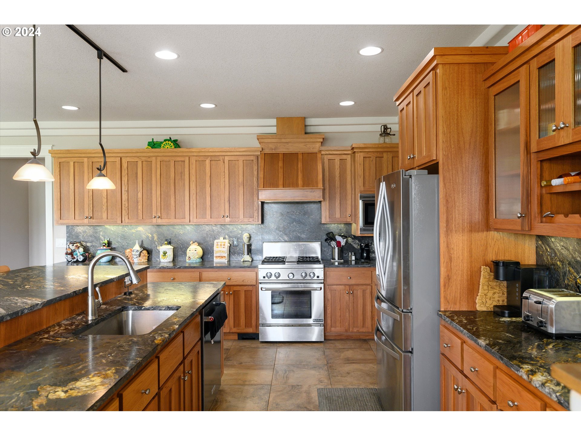 4216 Northwest 289th Street Ridgefield, WA 98642 - Photo 17 of 40 a kitchen with kitchen island granite countertop a refrigerator and a stove top oven