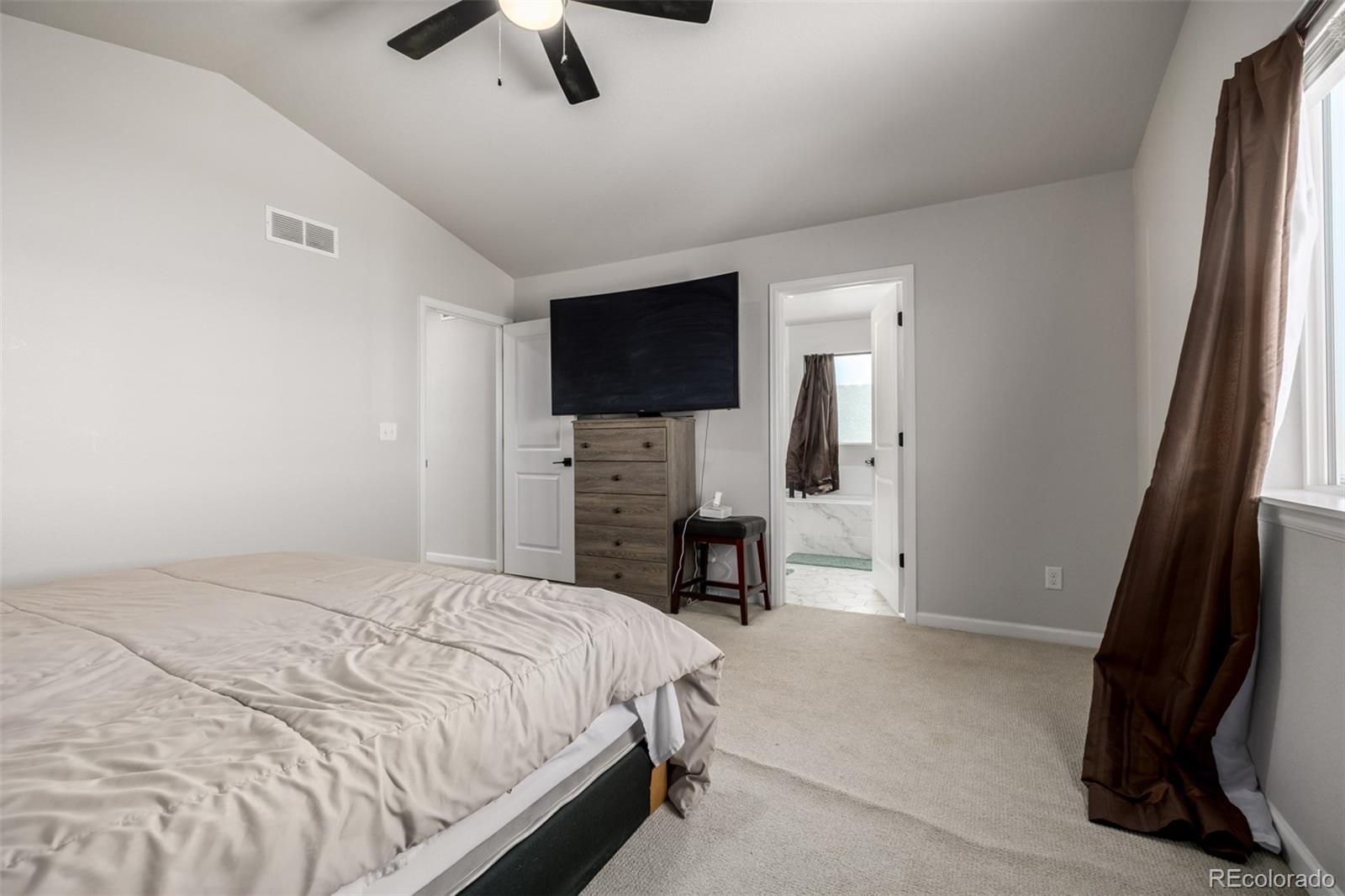 1875 Rancher Drive Milliken, CO 80543 - Photo 14 of 50 a bedroom with a bed and a flat screen tv