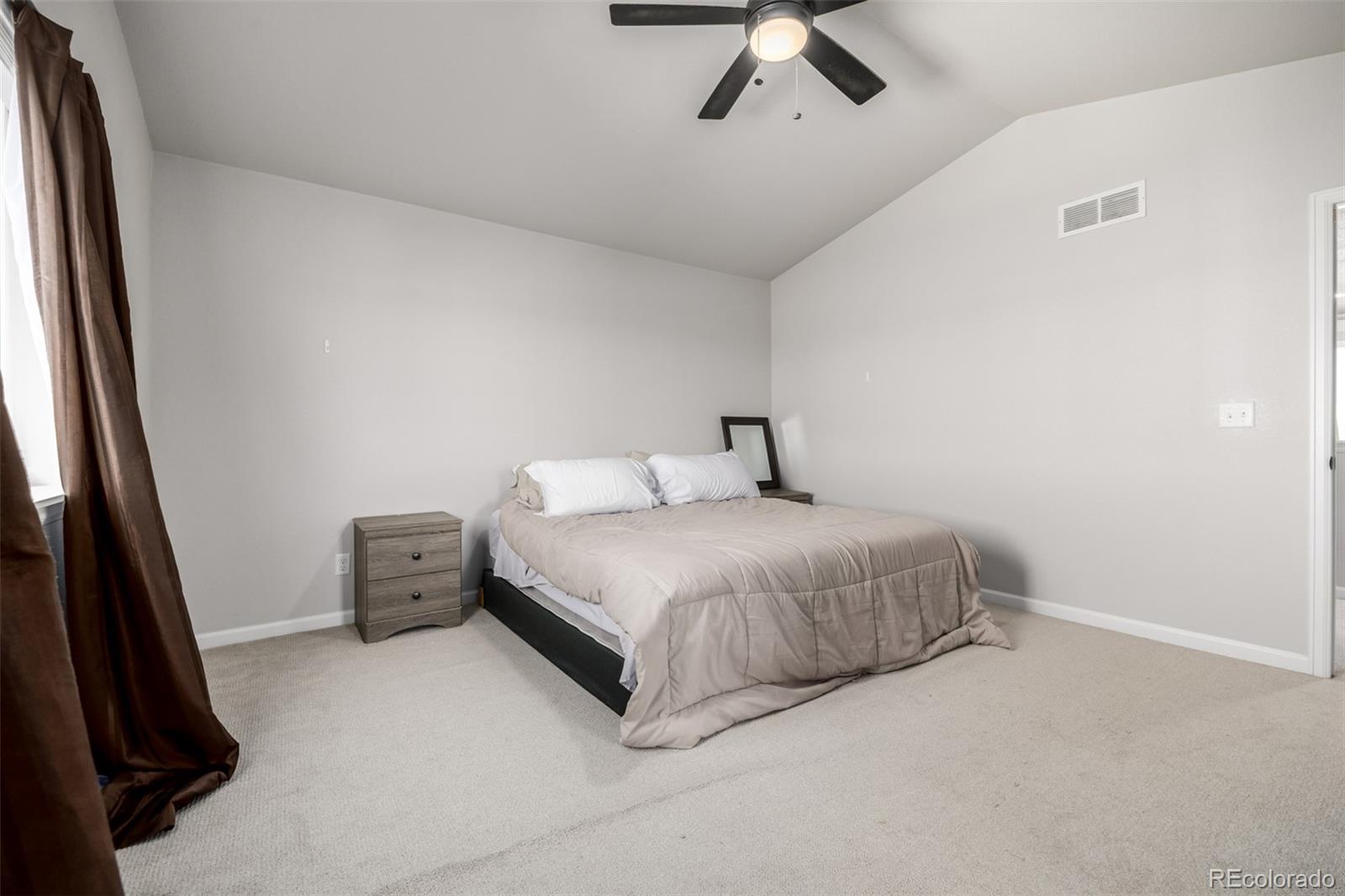 1875 Rancher Drive Milliken, CO 80543 - Photo 15 of 50 a bedroom with a bed and ceiling fan
