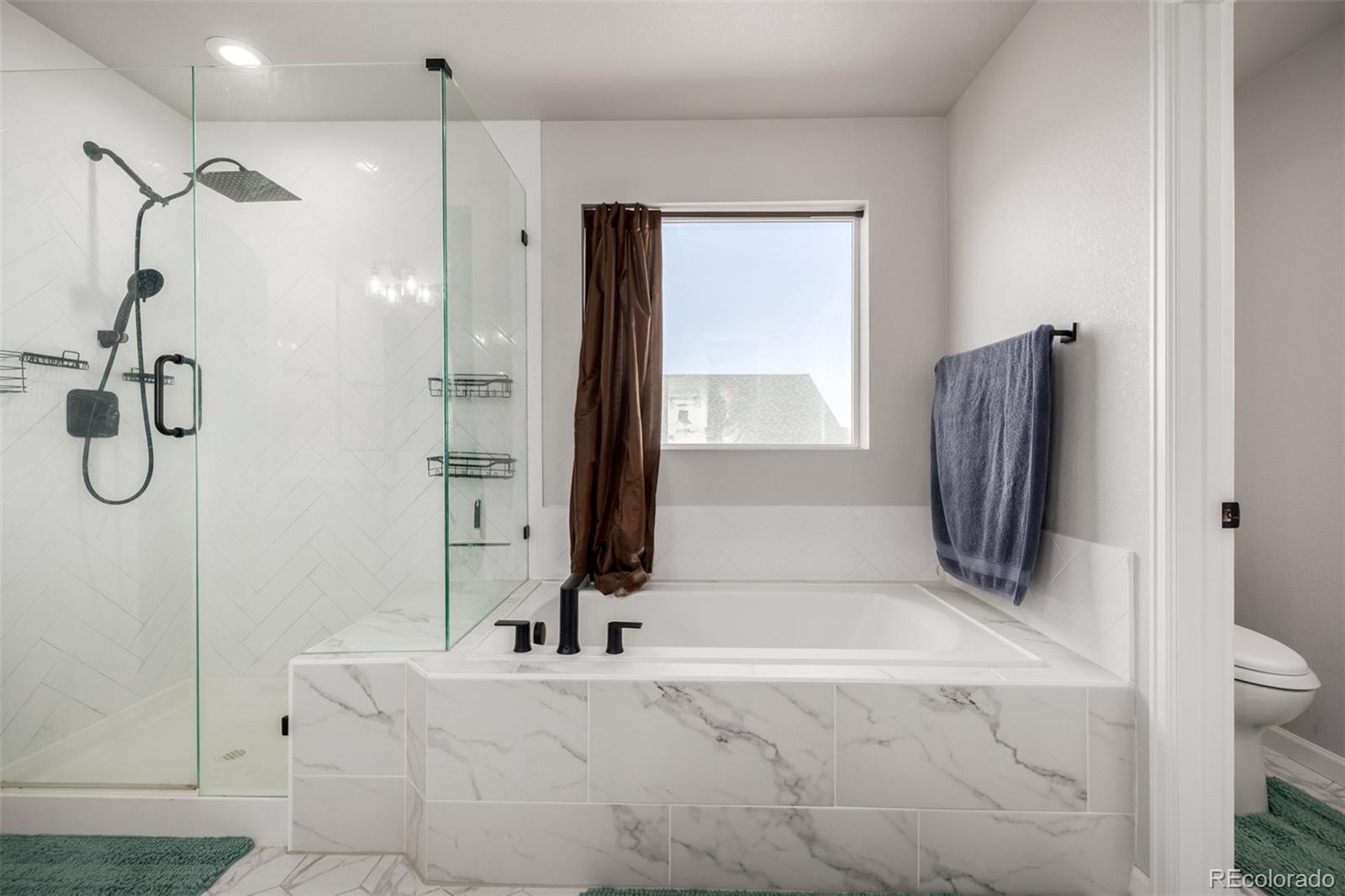 1875 Rancher Drive Milliken, CO 80543 - Photo 16 of 50 a bathroom with a tub sink and mirror