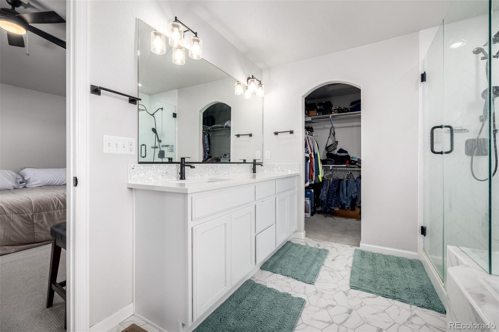 1875 Rancher Drive Milliken, CO 80543 - Photo 17 of 50 a bathroom with double vanity sink and a mirror