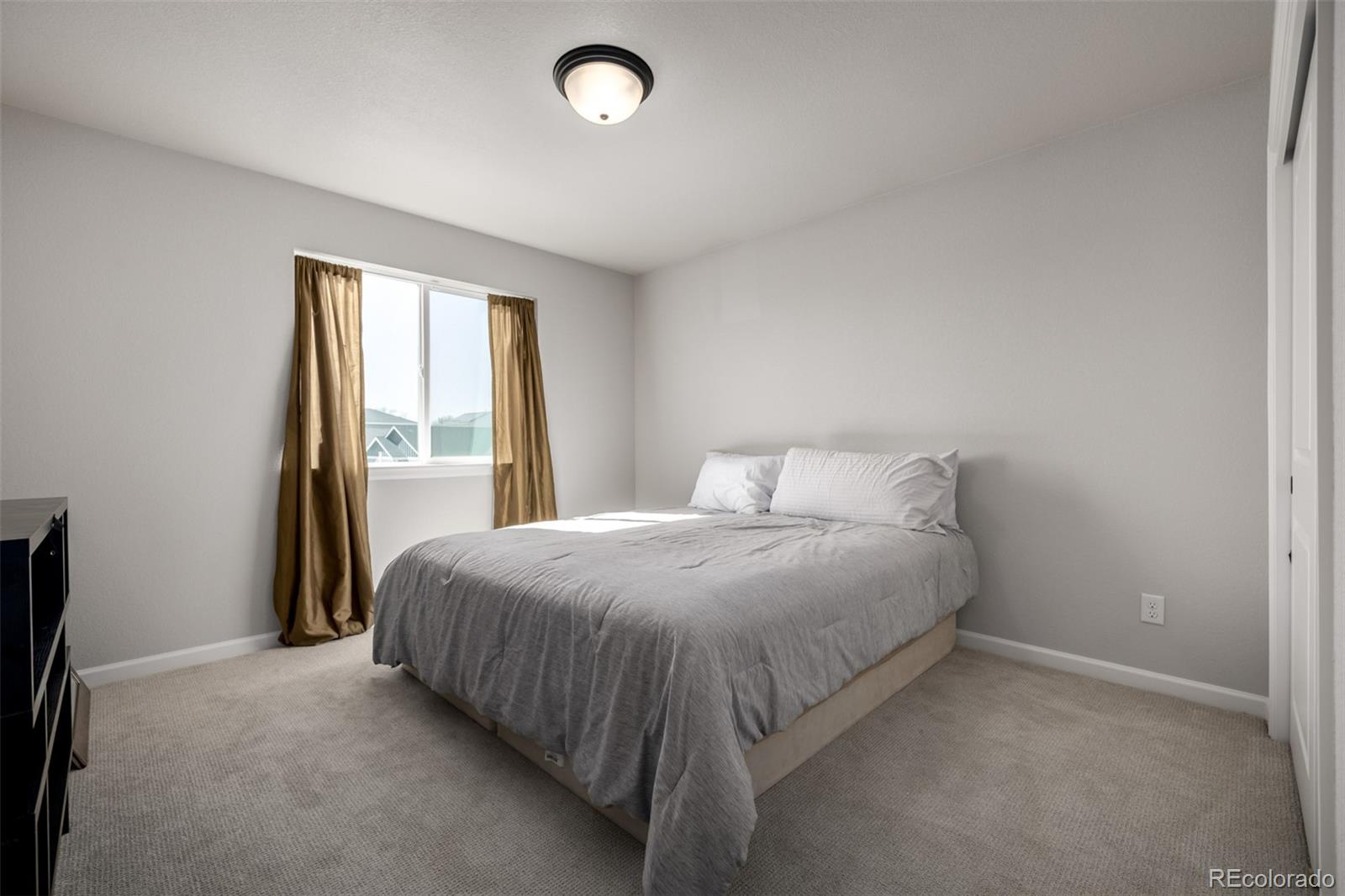 1875 Rancher Drive Milliken, CO 80543 - Photo 19 of 50 a bedroom with a bed and window