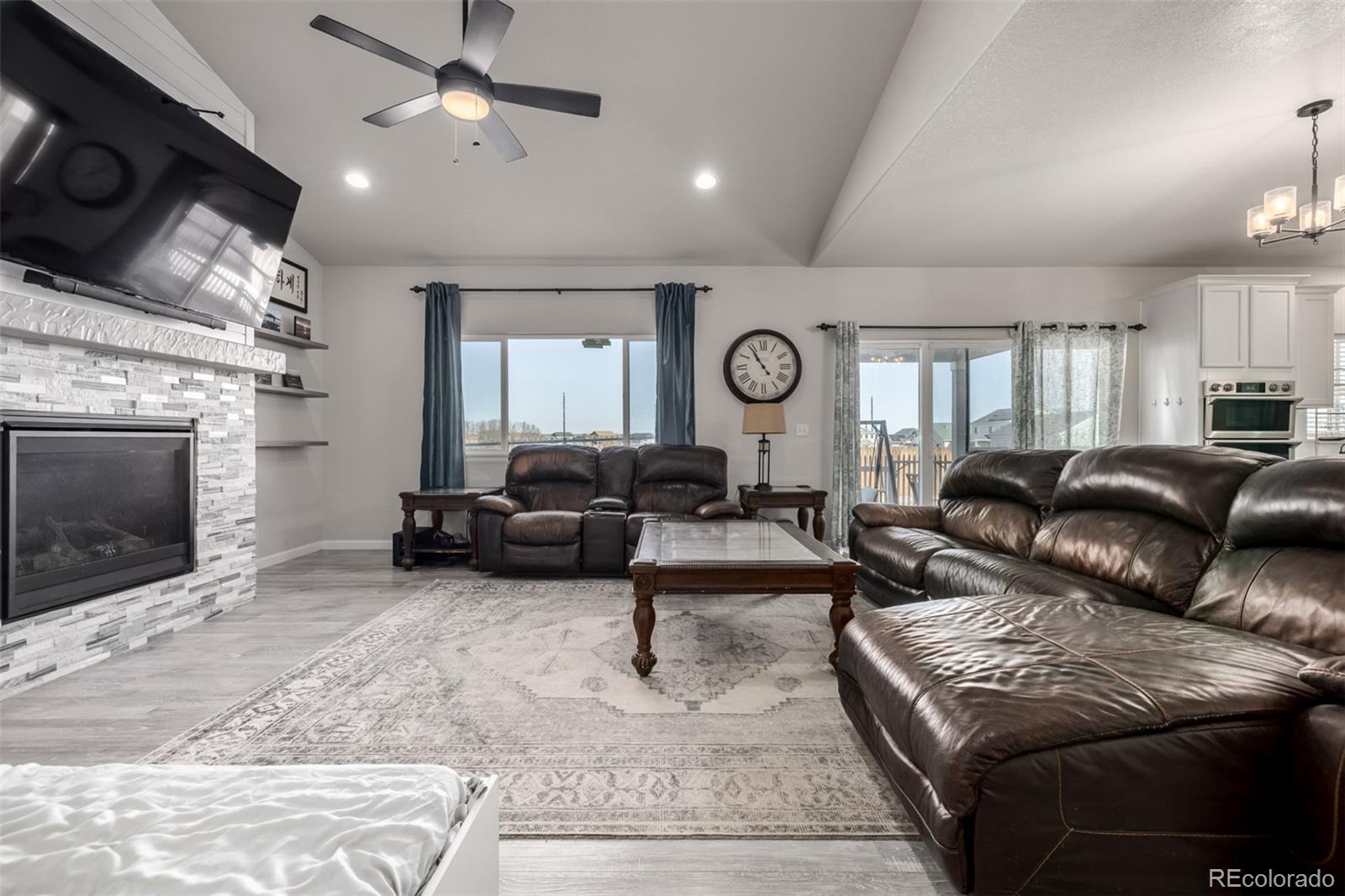 1875 Rancher Drive Milliken, CO 80543 - Photo 2 of 50 a living room with furniture a clock and a fireplace