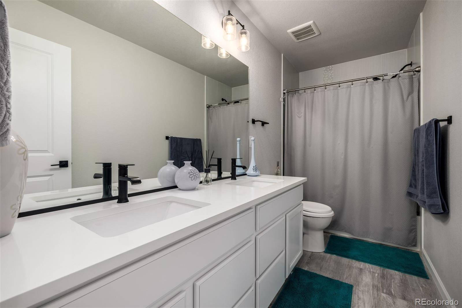 1875 Rancher Drive Milliken, CO 80543 - Photo 25 of 50 a bathroom with a sink a toilet and shower