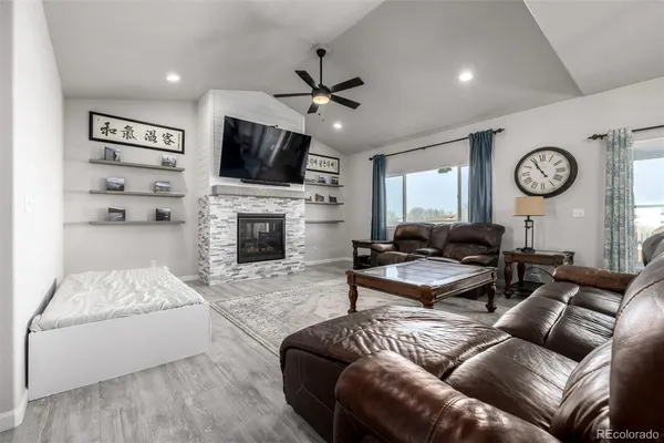 a living room with furniture a flat screen tv and a fireplace