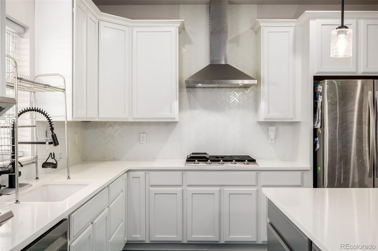 1875 Rancher Drive Milliken, CO 80543 - Photo 9 of 50 a kitchen with stainless steel appliances a sink stove and cabinets