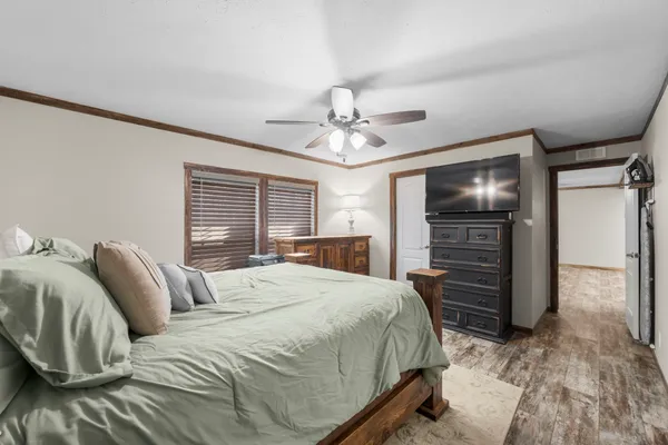 a bedroom with a bed and a ceiling fan