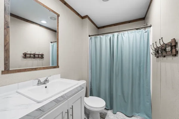 a bathroom with a sink a toilet and shower curtain
