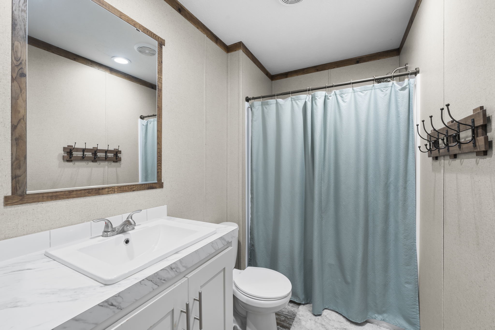 577 Winding River Road South Oakhurst, TX 77359 - Photo 22 of 31 a bathroom with a sink a toilet and shower curtain