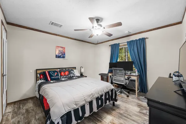 a bedroom with a bed and a dresser next to a window