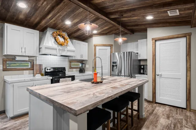 a kitchen with stainless steel appliances granite countertop a kitchen island a stove and a refrigerator