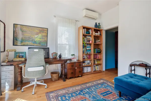 a living room with large windows and a potted plant