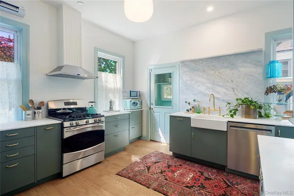 a kitchen with stainless steel appliances a stove a sink and cabinets