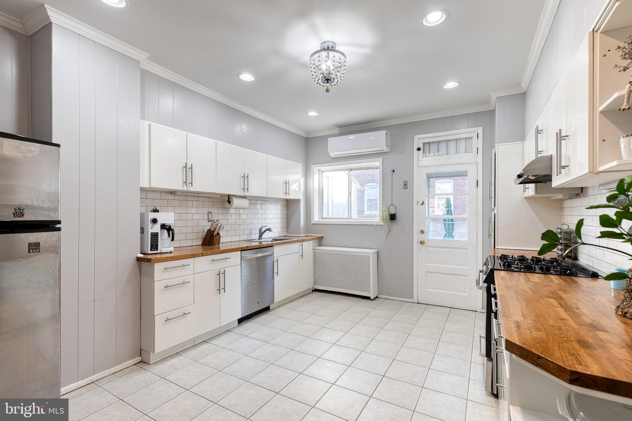 3903 Hudson Street Baltimore, MD 21224 - Photo 11 of 34 a large kitchen with granite countertop a white stove top oven and cabinets