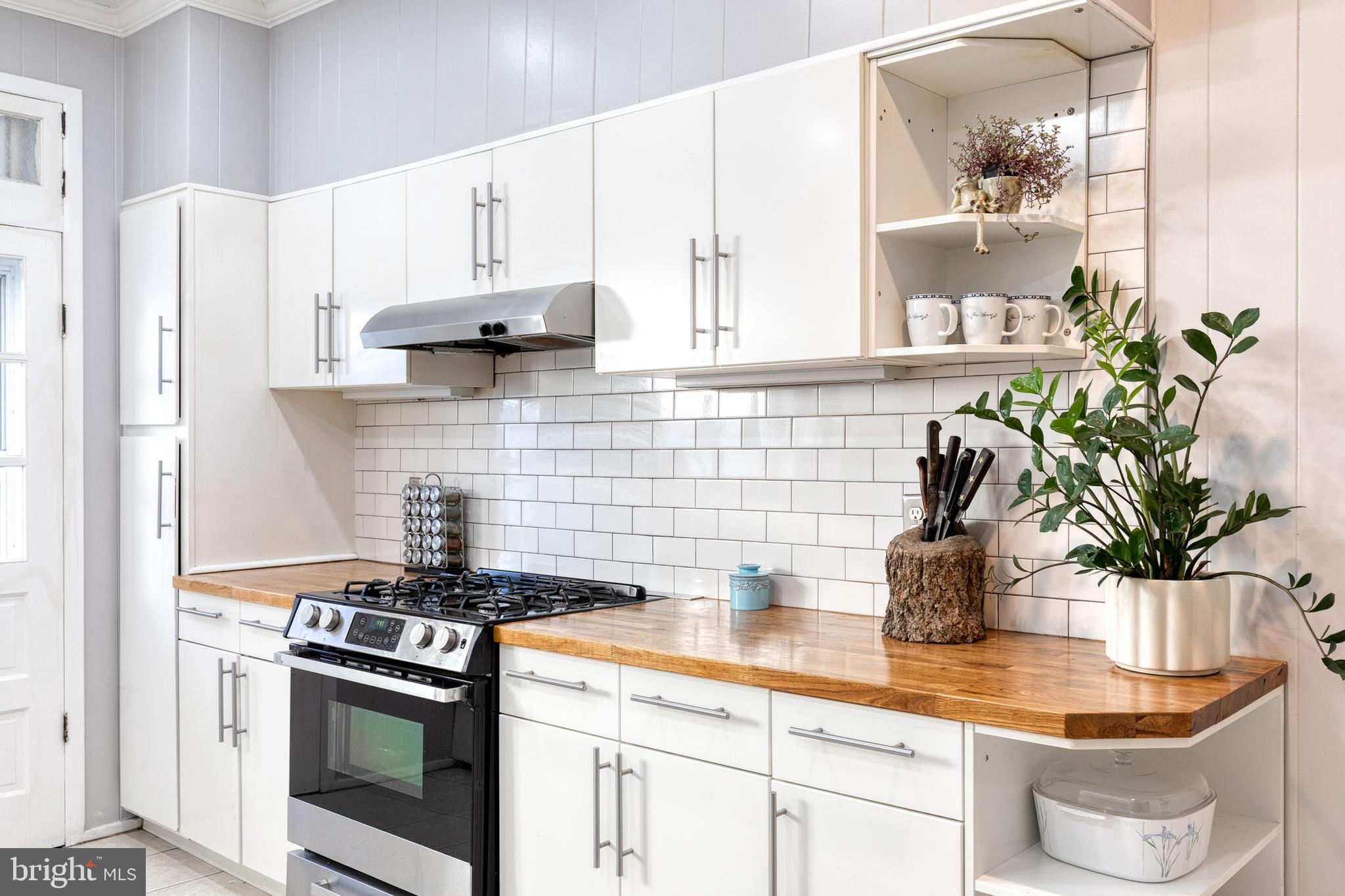 3903 Hudson Street Baltimore, MD 21224 - Photo 13 of 34 a kitchen with stainless steel appliances a white sink a stove a refrigerator a counter space and cabinets