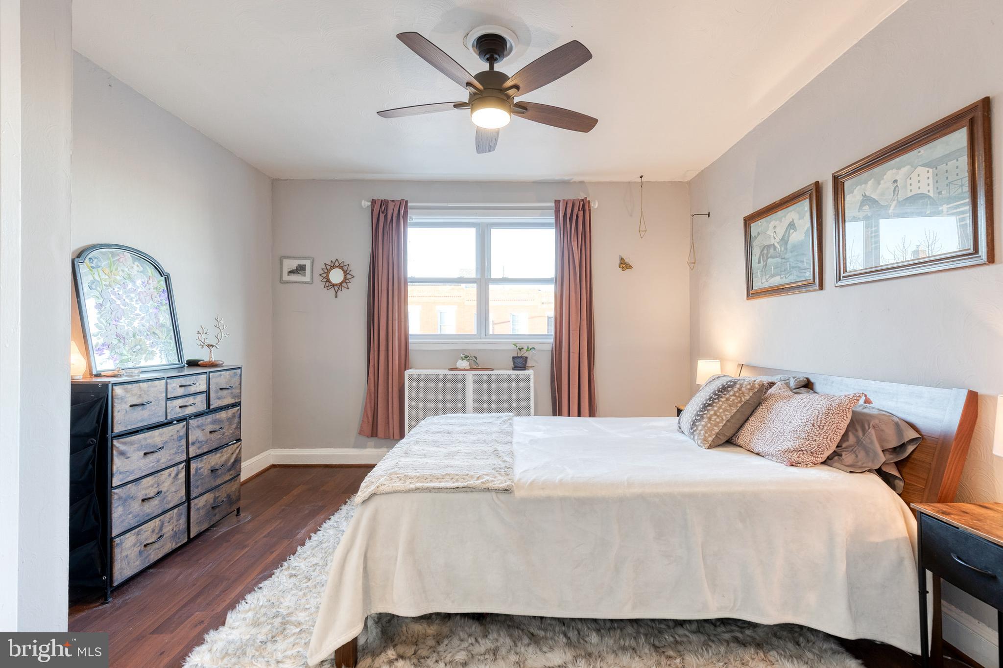 3903 Hudson Street Baltimore, MD 21224 - Photo 16 of 34 a bedroom with a bed and a dresser with wooden floor