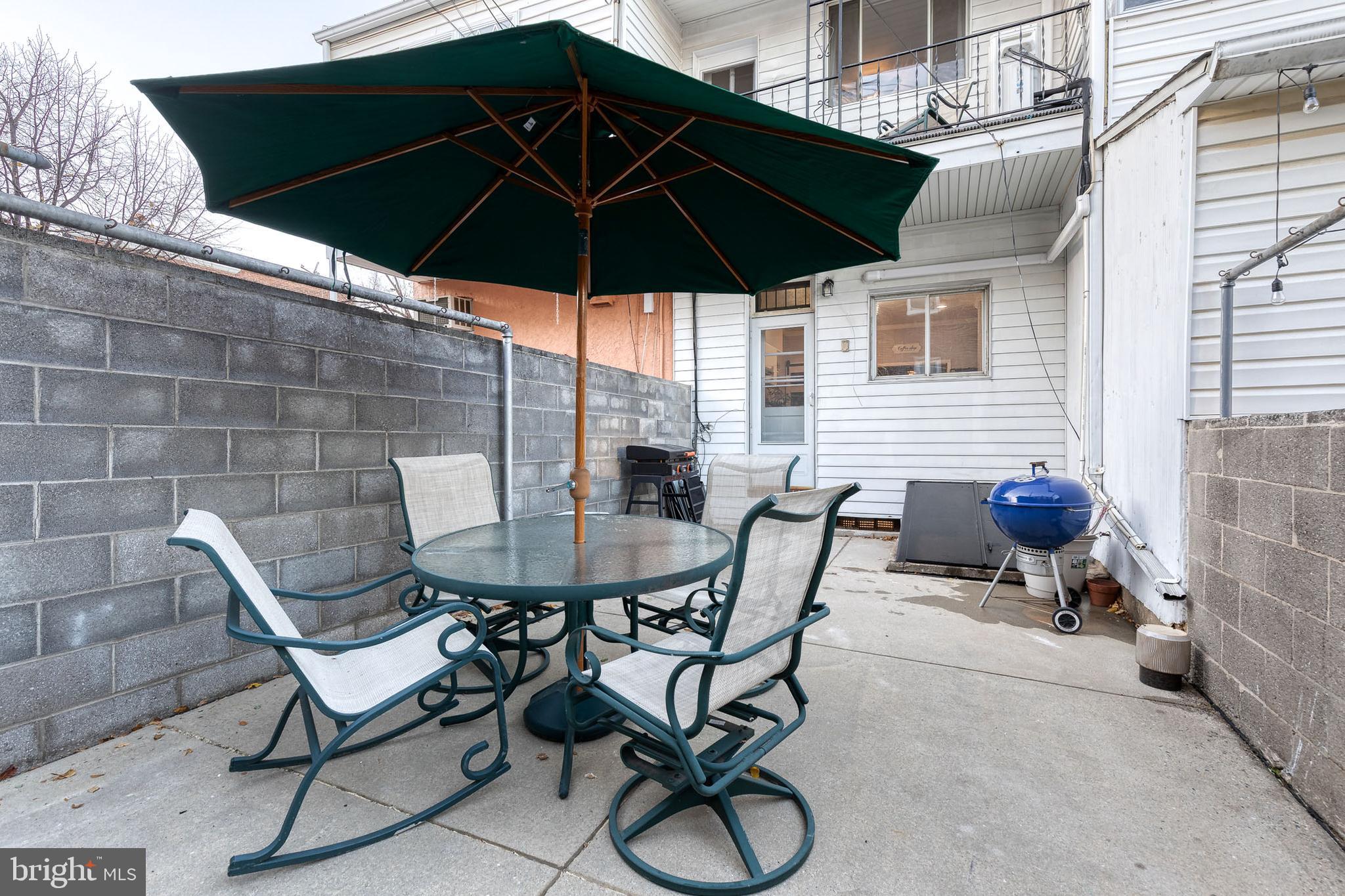 3903 Hudson Street Baltimore, MD 21224 - Photo 30 of 34 a view of a backyard with furniture and table under an umbrella