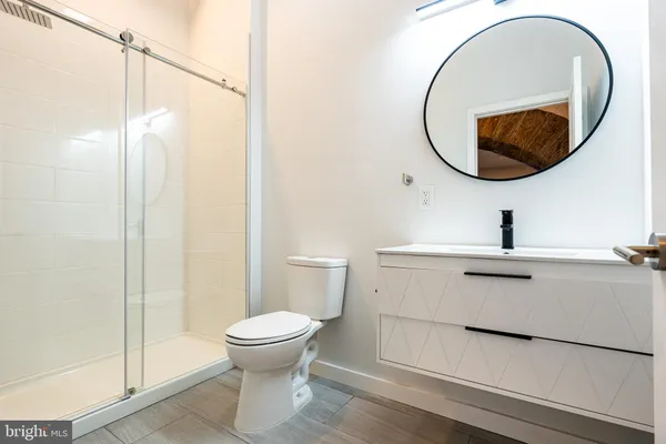 a bathroom with a sink a toilet and a mirror