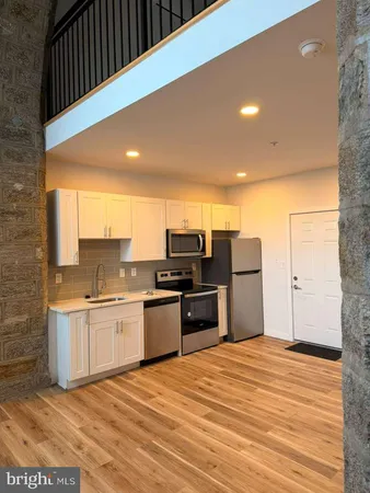 a kitchen with stainless steel appliances kitchen island granite countertop a table and chairs in it