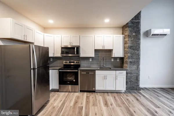 a kitchen with stainless steel appliances a refrigerator sink and microwave