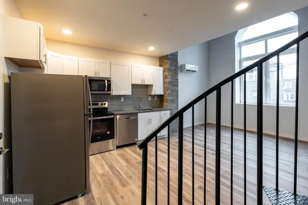 a kitchen with stainless steel appliances granite countertop a refrigerator a stove a sink and dishwasher next to a window