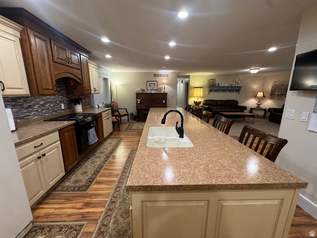 655 North 8th East Preston, ID 83263 - Photo 31 of 32 Kitchen with a breakfast bar, dark wood-type flooring, a large island, open floor plan, and black electric range oven