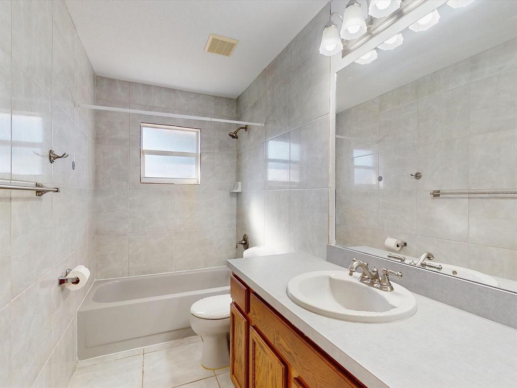 978 Alsace Drive Kissimmee, FL 34759 - Photo 18 of 30 a bathroom with a sink a toilet and shower