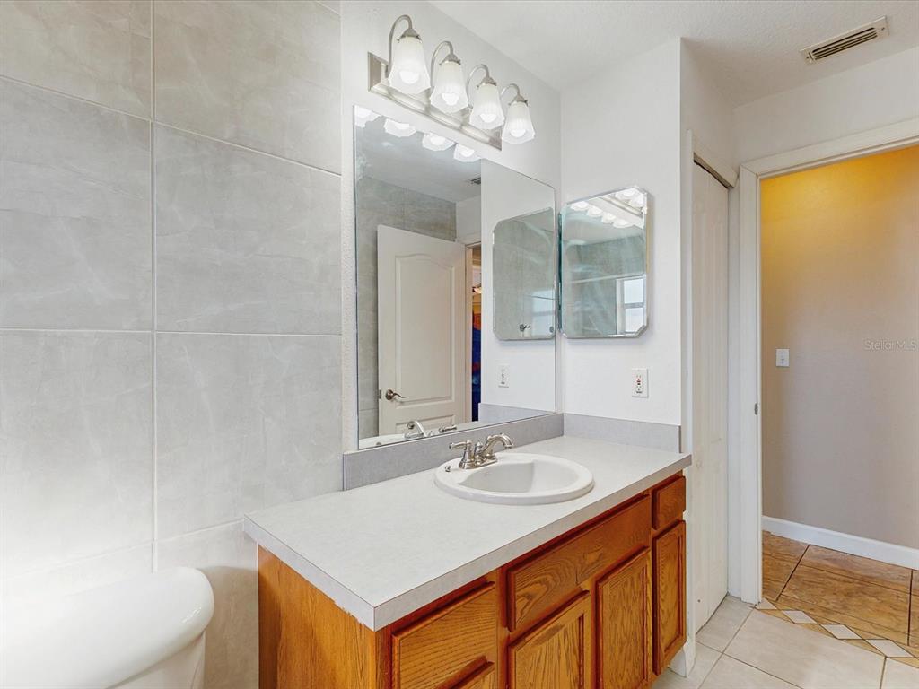 978 Alsace Drive Kissimmee, FL 34759 - Photo 19 of 30 a bathroom with a sink a toilet and a mirror