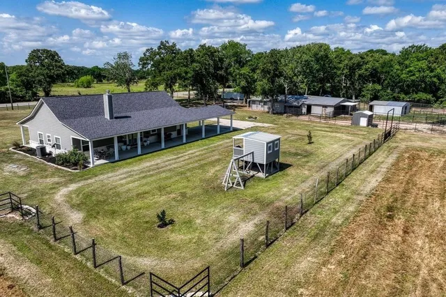 a view of swimming pool with outdoor seating and trees in the background