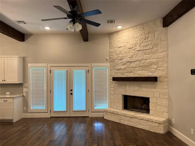 a view of a livingroom with wooden floor a fireplace and window