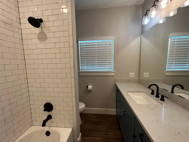 a bathroom with a sink a toilet a mirror and shower