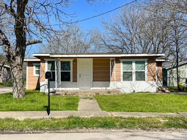 a front view of a house with a yard and plants