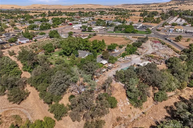 an aerial view of residential houses with outdoor space and trees