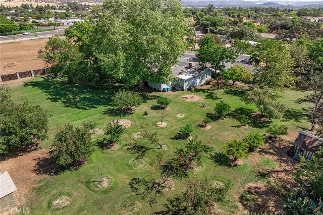 an aerial view of residential houses with outdoor space and trees
