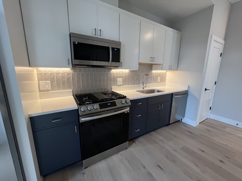 157 Everett Street, Unit 203 Boston, MA 02134 - Photo 5 of 11 a kitchen with a sink and a stove top oven