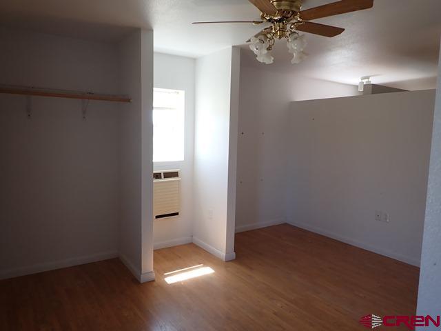10944 Mesa View Loop Eckert, CO 81418 - Photo 7 of 10 an empty room with wooden floor chandelier fan and windows