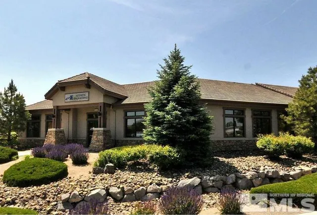 a front view of a house with a yard and potted plants